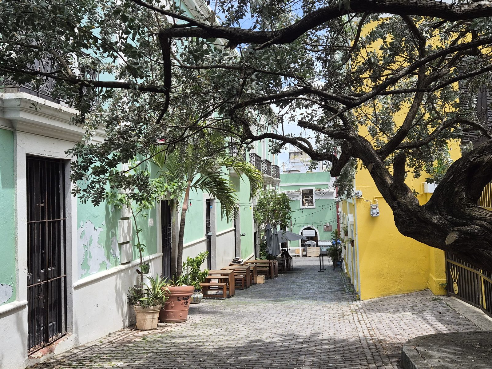 A shaded cobblestone street in Old San Juan with pastel facades